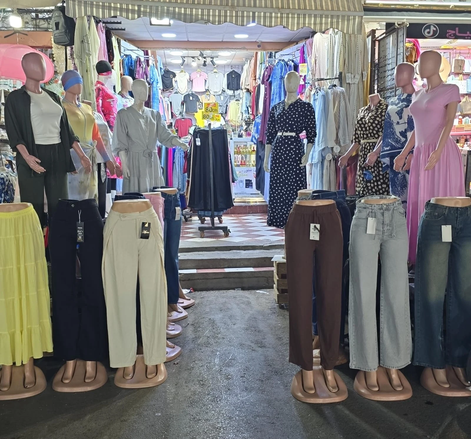 Entrance of Boutique Younes women's clothing store with dresses, tops and trousers on display